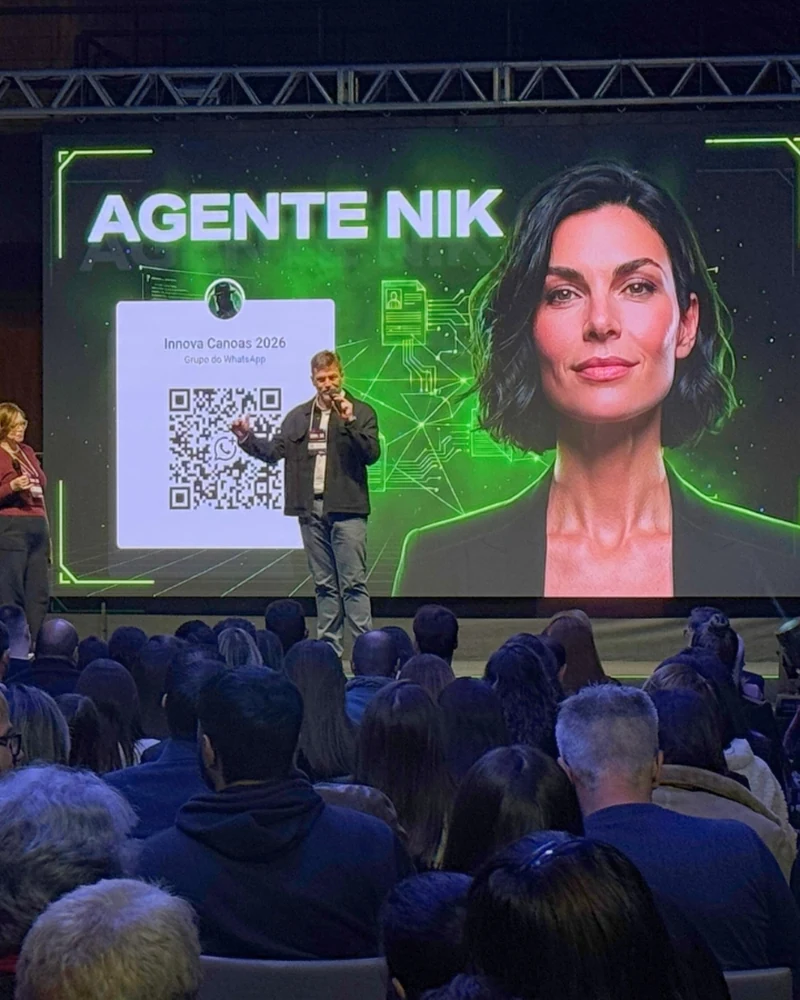 Rafa Wainberg apresentando um agente de IA no telão, diante de plateia cheia